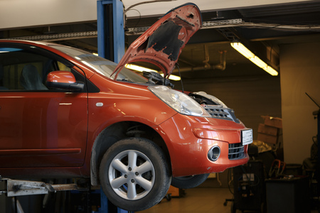 Car with an open hood in a repair stationの写真素材