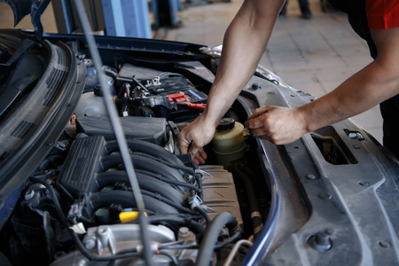 Auto mechanic working in garage. Repair service.の写真素材