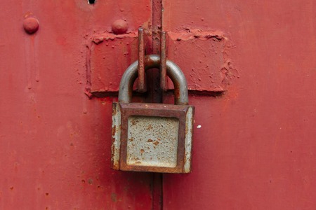 Locked Gate/Boarder Tethered by two metal chains (red and gold) and padlocks. Toned photo. Closed borders immigration concept.の写真素材
