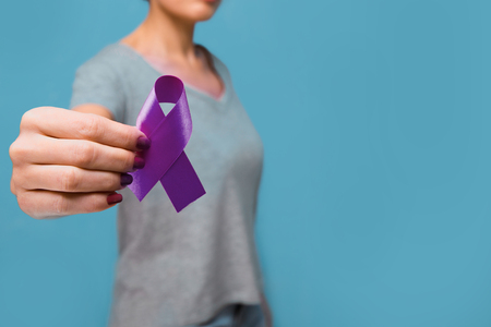 Elderly woman holding purple ribbon awareness w copy space. Symbol is used to raise awareness for Alzheimers disease, elder abuse, epilepsy, pancreatic cancer, thyroid cancer and lupus.の写真素材