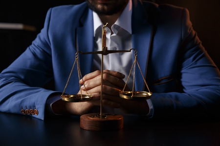 justice and law concept.Male lawyer in the office with brass scale on wooden table,の写真素材