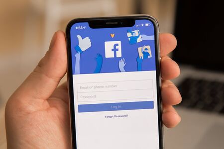 Tula, Russia - November 28, 2018: Facebook social media app logo on log-in, sign-up registration page on mobile app screen on iPhone smart devices in business persons hand at workのeditorial素材