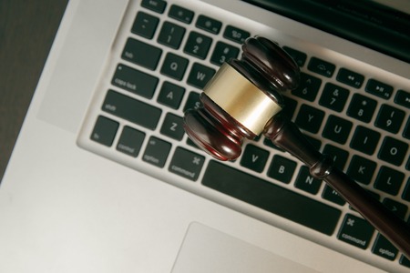 Workspace hero header with law gavel.Online auction concept. Auction or judge gavel on a computerの写真素材