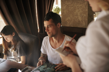 Handsome man making order at restaurantの写真素材