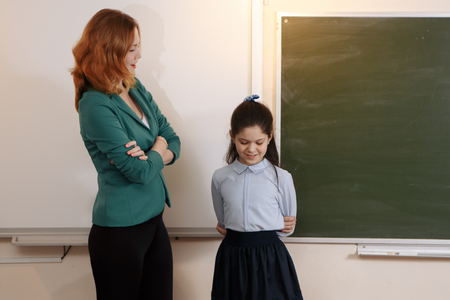 teacher and student at laptop, girl pointing at screenの写真素材