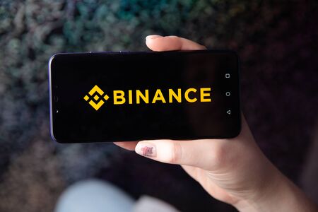 Tula, Russia - November 28, 2018: Apple iPhone and Binance logo and bitcoin, ethereum and dollars. is a cryptocurrency exchange.のeditorial素材