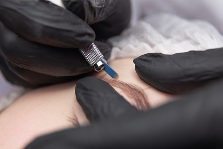 Permanent Makeup For Eyebrows. Microblading brow. Beautician Doing Eyebrow Tattooing For Female...