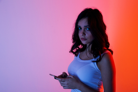 girl excessively sitting at the phone at home. he is a victim of online bullying Stalker social networksの写真素材