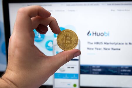 Tula, Russia - JANUARY 27, 2019: bitcoins, dollars and Huobi logo on the screen smartphone. Huobi -...
