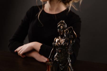 Closeup view of Statue of Justies and woman in a black clothes backgrowndの写真素材