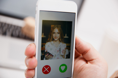 Online dating app in smartphone. Man looking at photo of beautifulの写真素材