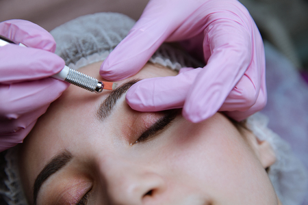 Permanent Makeup For Eyebrows. Microblading brow. Beautician Doing Eyebrow Tattooing For Female...