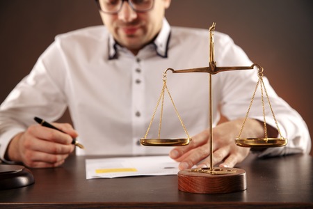 Close up lawyer businessman working or reading lawbook in office workplace.の写真素材