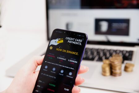Tula, Russia - February 18, 2019: Binance logo, and dollars. Binance is a cryptocurrency exchange.