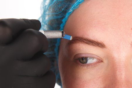 Permanent Makeup For Eyebrows. Microblading brow. Beautician Doing Eyebrow Tattooing For Female...