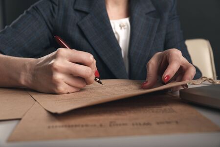 Closeup view of woman attorney writing on documents by pen.の写真素材