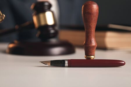 Closeup view of pen, seal and wooden gavel on the table isolated