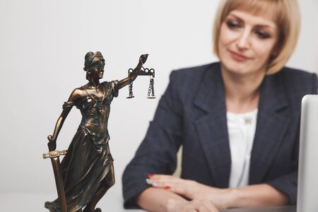 Jurisprudence concept. Woman advocate at the desk sitting isolated.の写真素材