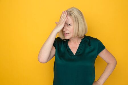 Amazed by bad news woman holding her hand on her head.の写真素材