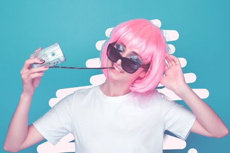 Young girl 90s and VHS cassette on blue background.