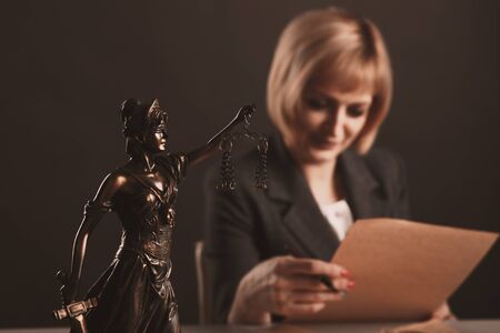 Female working at the desk with paper documents. Attorney concept.