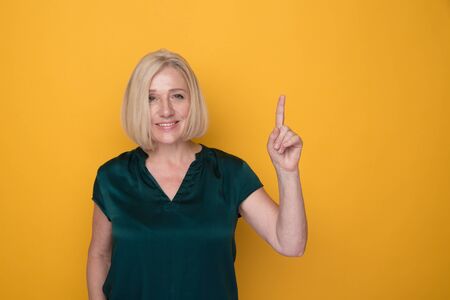 Portrait of woman with happy face showing something by her finger.の写真素材