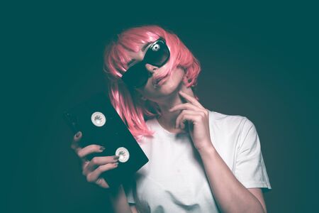 Young girl 90s and VHS cassette on pinkの写真素材