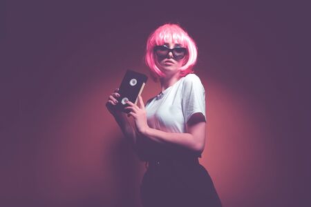 Young girl 90s and VHS cassette on pink