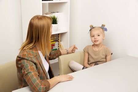 Mother talking to the daughter at home and smiling.の写真素材
