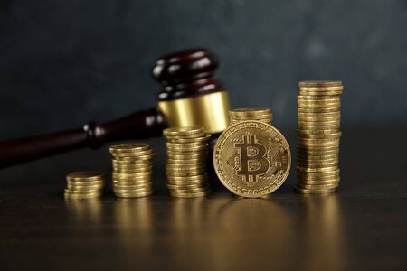 Auction gavel and bitcoin cryptocurrency money on a wooden desk, close-up. Law Gavel and golden bitcoin symbol on white background withの写真素材
