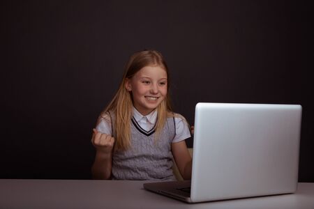 Cute smiling girl using computer isolated.
