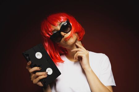 Young girl 90s and VHS cassette on pinkの写真素材