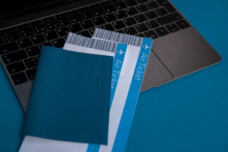 Closeup view of blue passport and tickets inside on the laptop