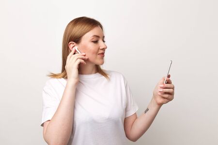 Tula, Russia - JANUARY 24, 2019: Happy woman listening music Apple AirPodsのeditorial素材