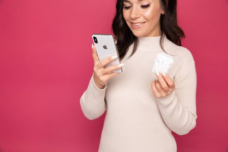 Tula, Russia - JANUARY 24, 2019: Happy woman listening music Apple AirPods