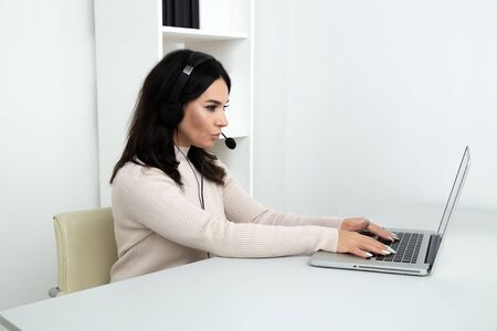 Female operator of call center sitting at her workplace.