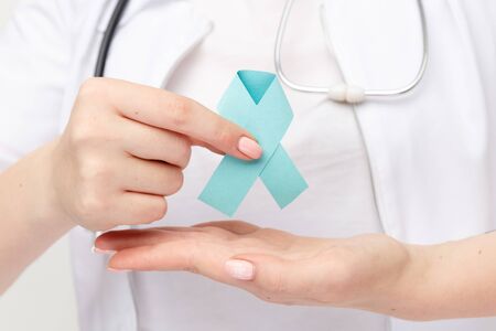 Female doctor holding blue ribbon isolated.の写真素材