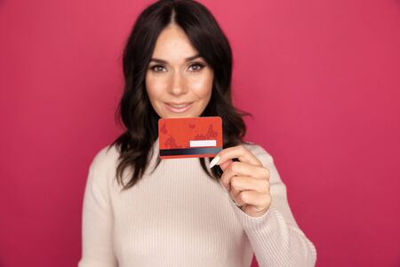 Advertising concept. Lady smiling and showing credit card isolated.