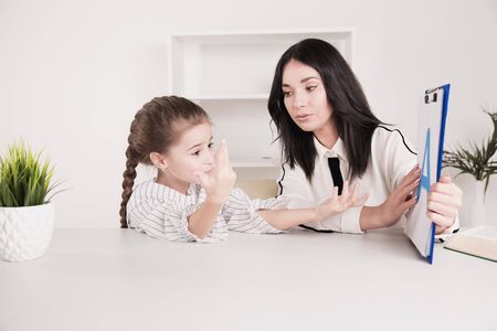Teacher and litle girl working on a pronunciation together in the class.の写真素材