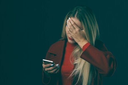 Depressed sad woman holding phone isolated.の写真素材