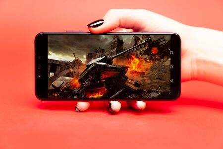 26 08 2019 Tula: World of tanks game on the phone display on the red background.