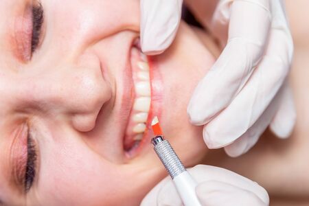 Cosmetic procedures for the treatment of eyebrows. Microblading in the beauty salon. Professional cosmetology. The process of applying the pigmentの写真素材