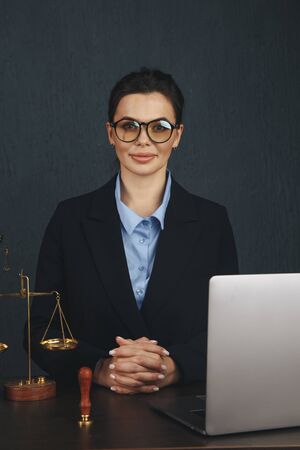 Lawyer office. Statue of Justice with scales and lawyer working on a laptop. Legal law, advice and justice .の写真素材