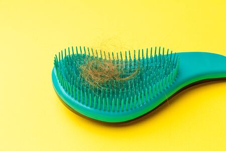 young woman worried about hair loss on a white background.の写真素材
