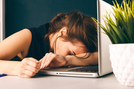 Bored sleepy woman tired. Office worker sleeping at her deskの写真素材