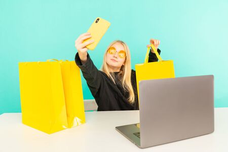 Happy girl at home speaking in front of camera for vlog. Young black woman working as blogger, recording video tutorial for Internet.の写真素材