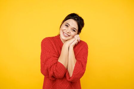 Cute glad brunette woman in red clothers in the yellow studio.