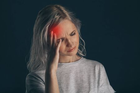 Woman in stress with pain on her face feeling headache.の写真素材