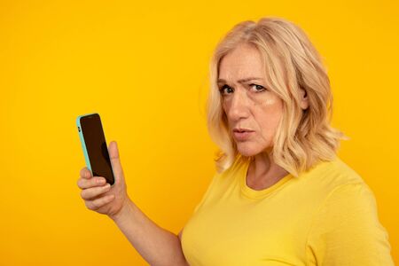 Stunned frustrated woman holding phone isolated. Bad mobile concept.