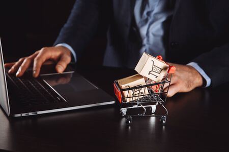 Boxes in a trolley on a laptop keyboard. Ideas about online shopping, online shopping is a form of electronic commerce that allows consumers to directly buy goods from a seller over the internet.の写真素材